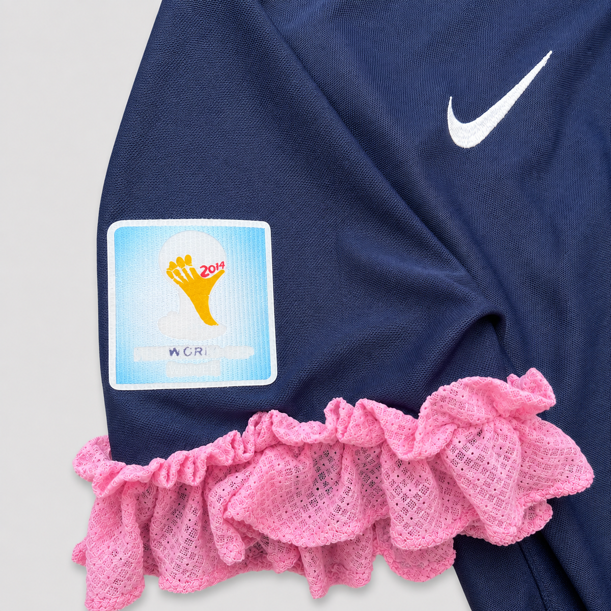 Détail des volants roses ajoutés aux manches du maillot upcyclé OHBAB