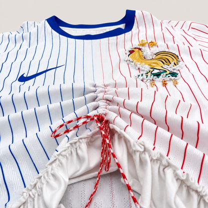 Maillot de football bleu,blanc,rouge upcyclé OHBAB à lignes bleues et rouges, avec fronces, volant blanc sur les manches et écusson brodé de perlescolorées.