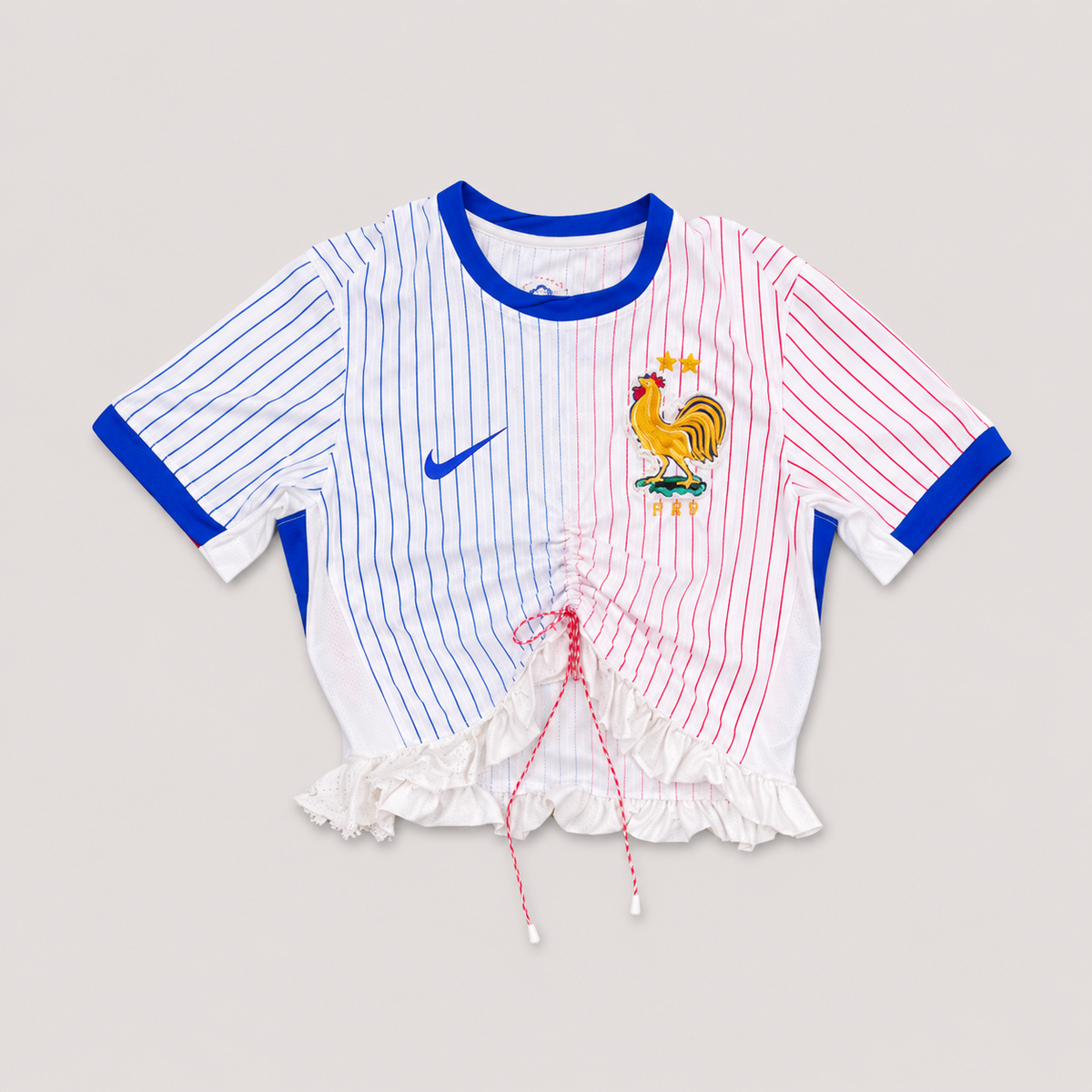Maillot de football bleu,blanc,rouge upcyclé OHBAB à lignes bleues et rouges, avec fronces, volant blanc sur les manches et écusson brodé de perlescolorées.