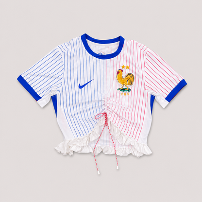 Maillot de football bleu,blanc,rouge upcyclé OHBAB à lignes bleues et rouges, avec fronces, volant blanc sur les manches et écusson brodé de perlescolorées.