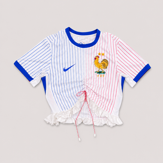 Maillot de football bleu,blanc,rouge upcyclé OHBAB à lignes bleues et rouges, avec fronces, volant blanc sur les manches et écusson brodé de perlescolorées.