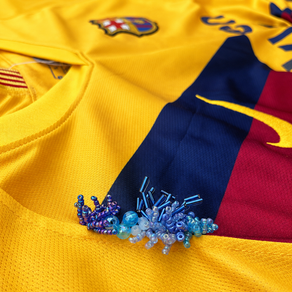 Détail des perles bleues brodées à la main
sur le maillot.