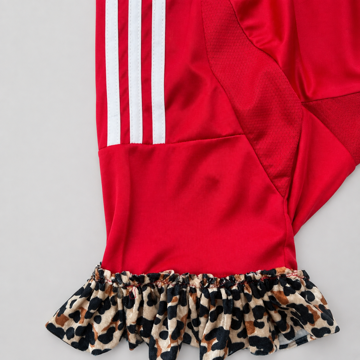 Détail des volants léopard ajoutés à la main sur les manches du maillot rouge OHBAB.