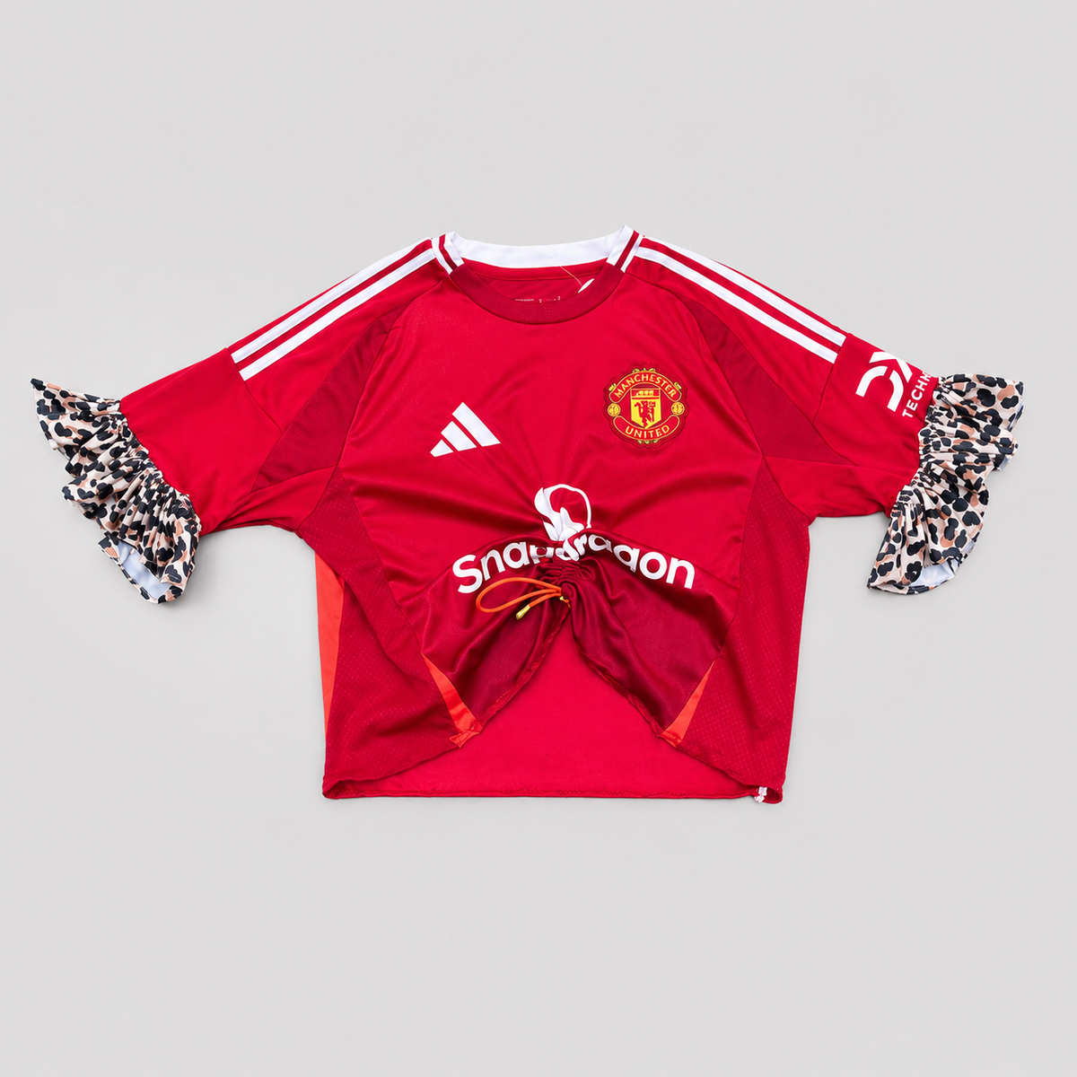 Maillot de football rouge upcyclé OHBAB vu de face avec volants léopard et fronce réglable.