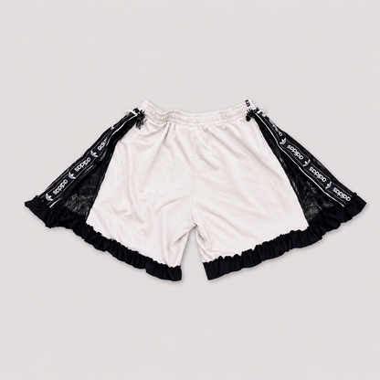 Short de football blanc transformé à la main à Bayonne avec dentelle noire, volants et perles reliant le devant au dos. Pièce unique OHBAB.