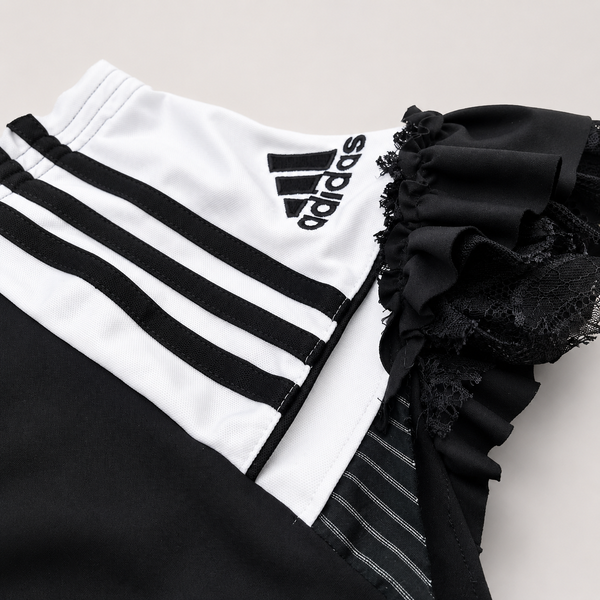 Détail des empiècements sportswear noirs et blancs et de la dentelle du shorty OHBAB.