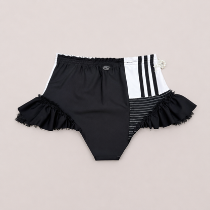 Dos du shorty taille haute HOT SHOT avec assemblage asymétrique et volants noirs.