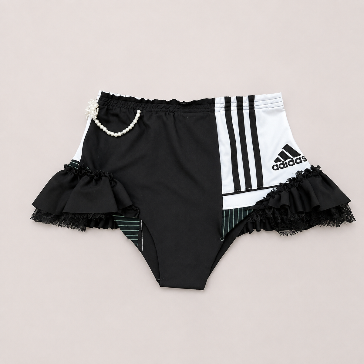 HOT SHOT, shorty sportswear noir et blanc upcyclé OHBAB vu de face avec volants, dentelle et perles.